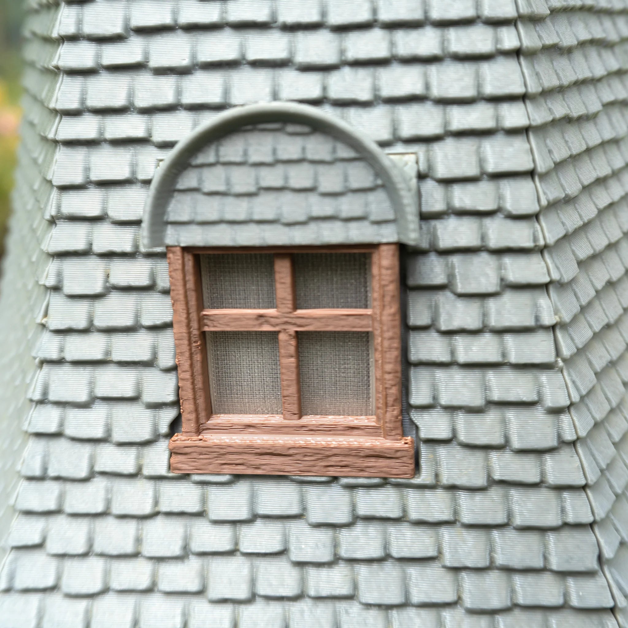 Dachfenster mit Rundgiebel, Holzrahmen und Gitterwerk auf grauem Ziegeldach