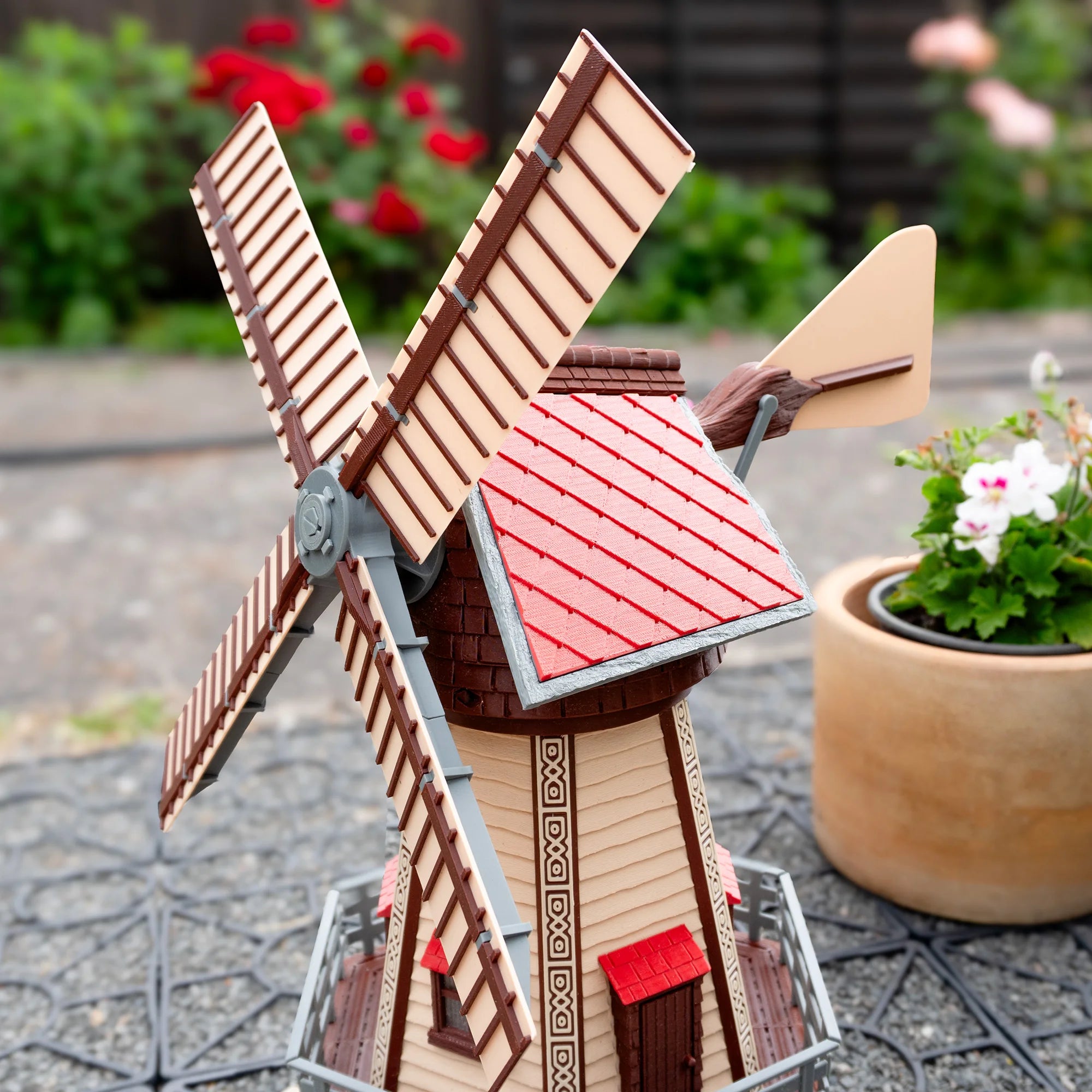 Jutland Mill Brande 3D-Druckmodellbausatz - montierte Windmühle mit roten Flügeln im Garten